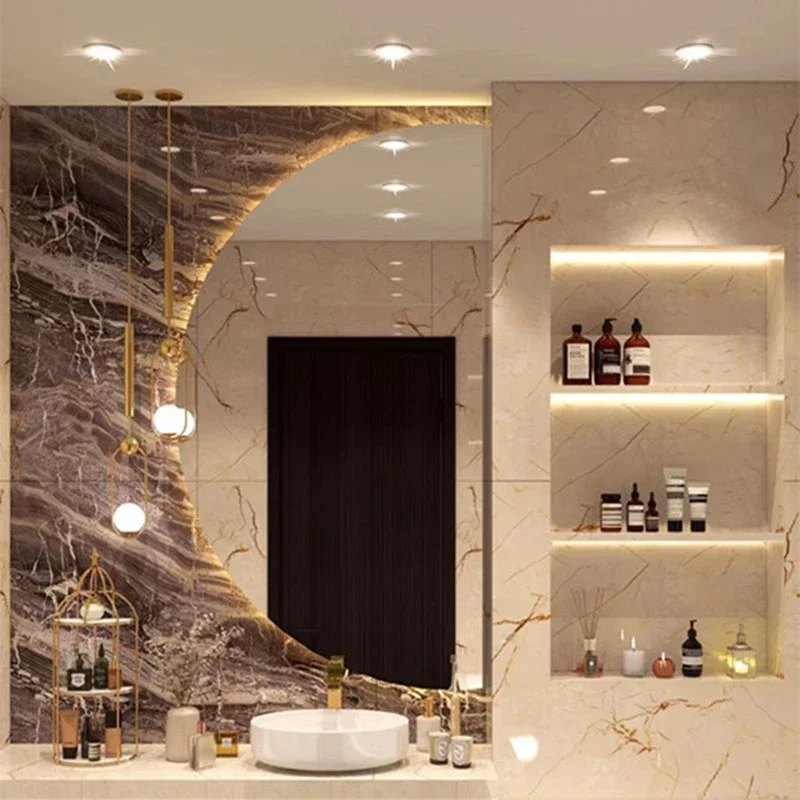 Elegance Luxury Half Moon Glow mirror with warm backlighting, set against marble walls and hanging lights above a white vessel sink.