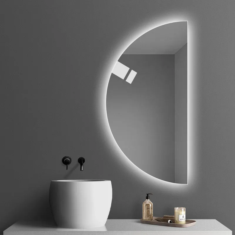 Elegance Luxury Half Moon Glow mirror with cool backlighting, mounted on a grey wall beside a white vessel sink and vanity.
