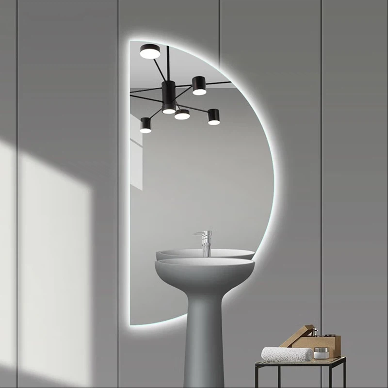 Elegance Luxury Half Moon Glow mirror with a vertical backlit design positioned behind a modern grey pedestal sink.
