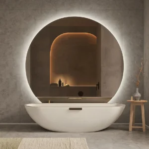 Modern bathroom with round backlit mirror above freestanding tub, warm niche lighting—Statement Mirrors as Decorative Focal Points