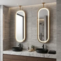 Twin oval backlit mirrors above a marble bathroom vanity with two black vessel sinks.