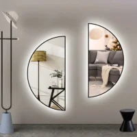 Two black-framed Half Moon Backlight mirrors with cool white glows, mounted symmetrically on a light wall in a modern room.