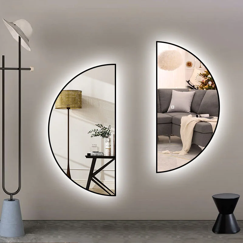 Two black-framed Half Moon Backlight mirrors with cool white glows, mounted symmetrically on a light wall in a modern room.