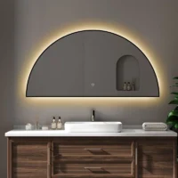 Framed Half Moon Backlight mirror with a black frame and warm glow, mounted above a dark wood vanity with a white vessel sink.
