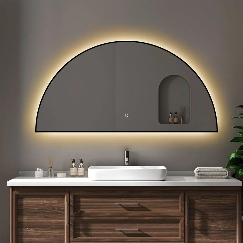 Framed Half Moon Backlight mirror with a black frame and warm glow, mounted above a dark wood vanity with a white vessel sink.
