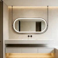 Modern bathroom with an oval backlit mirror above a floating white sink and matte black fixtures.