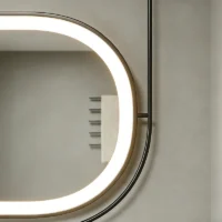 Close-up of a circular LED vanity mirror with a bright ring light mounted on a gray wall, showing its rounded edge and frame.