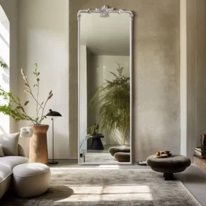 A Vintage Princess Full Length Rectangle Wall Mirror with an ornate silver crest, leaning in a bright, modern living room.