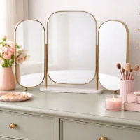 Gold Triple Dressing Foldable Table Mirror with three rounded panels and a white base on a vanity.