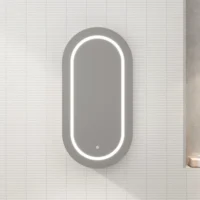 Oval backlit wall mirror with an LED rim mounted on a white tiled bathroom wall. Ideal for grooming and reflecting light.