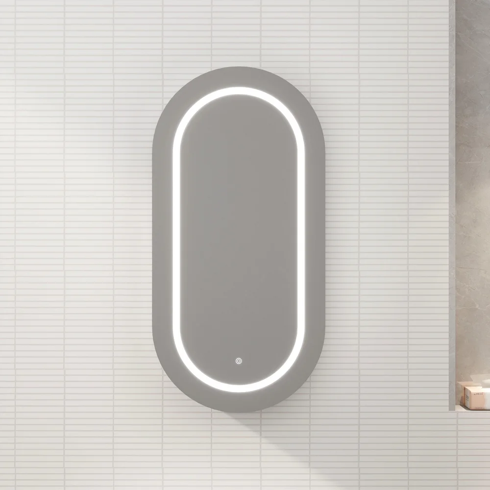 Oval backlit wall mirror with an LED rim mounted on a white tiled bathroom wall. Ideal for grooming and reflecting light.