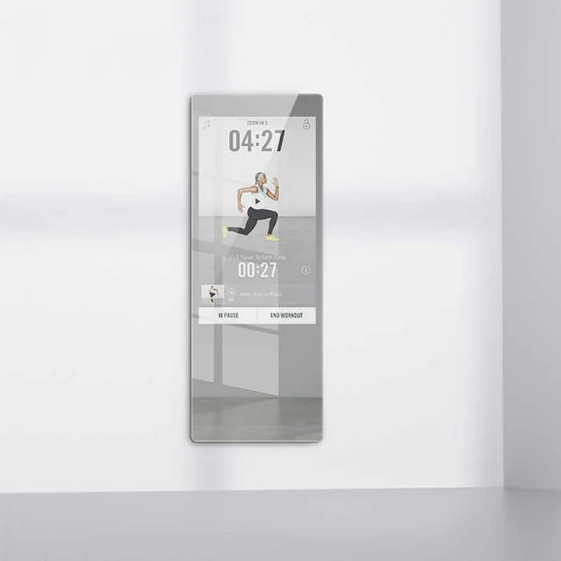 Wall-mounted smart fitness mirror showing a person doing a lunge exercise with a 4:27 timer on screen.