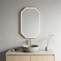 Geometric octagonal mirror with a gold frame above a marble countertop sink on a light wood vanity in a minimalist bathroom.