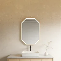 Octagonal backlit mirror above a white rectangular sink on a light wood vanity with a beige wall. For accessibility: describes the key elements and their arrangement.