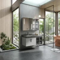 Modern bathroom interior with wall-mounted cabinets, marble sink counter, and glass doors opening to a landscaped garden courtyard.