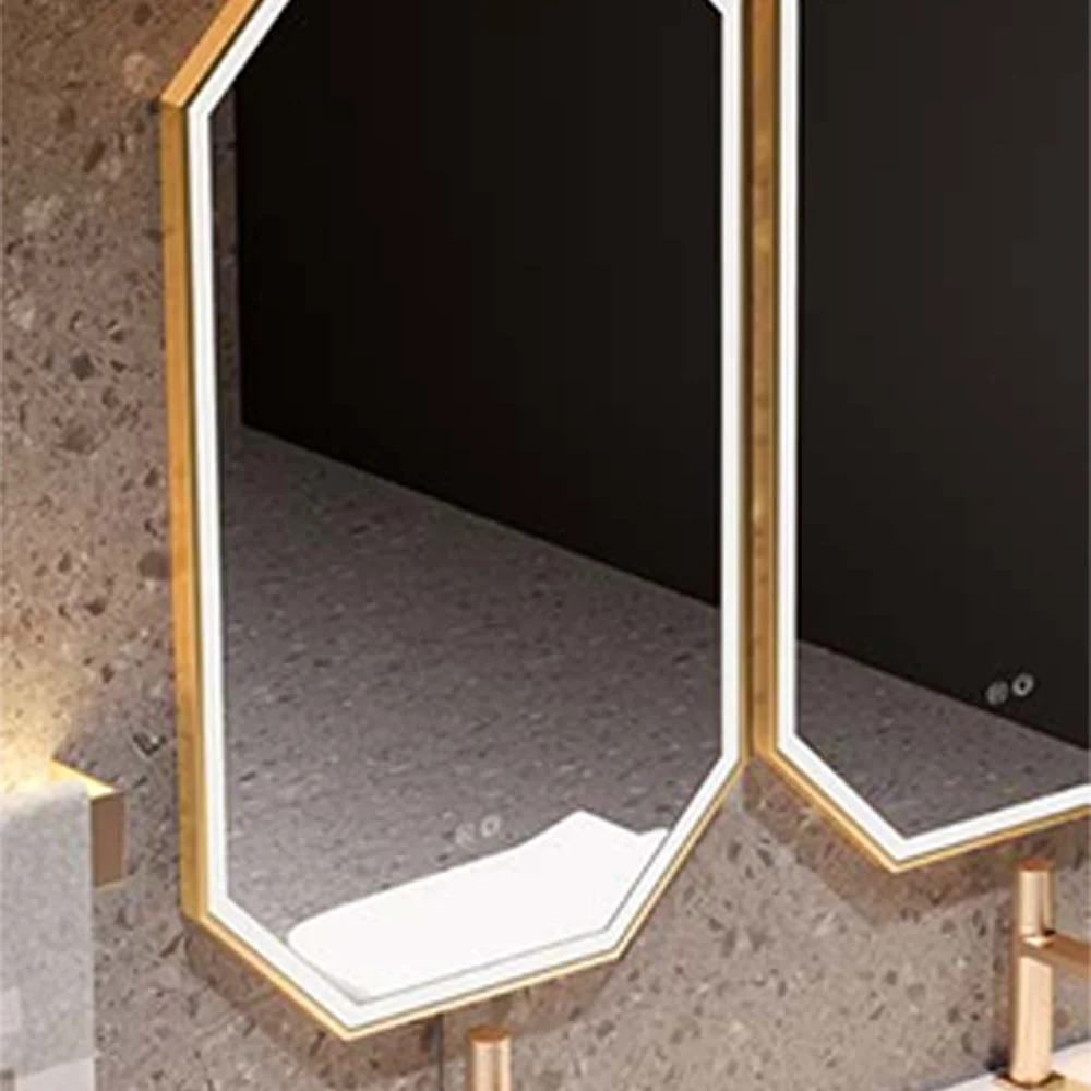 Gold-framed hexagonal mirrors with backlighting mounted above a marble vanity in a modern bathroom.
